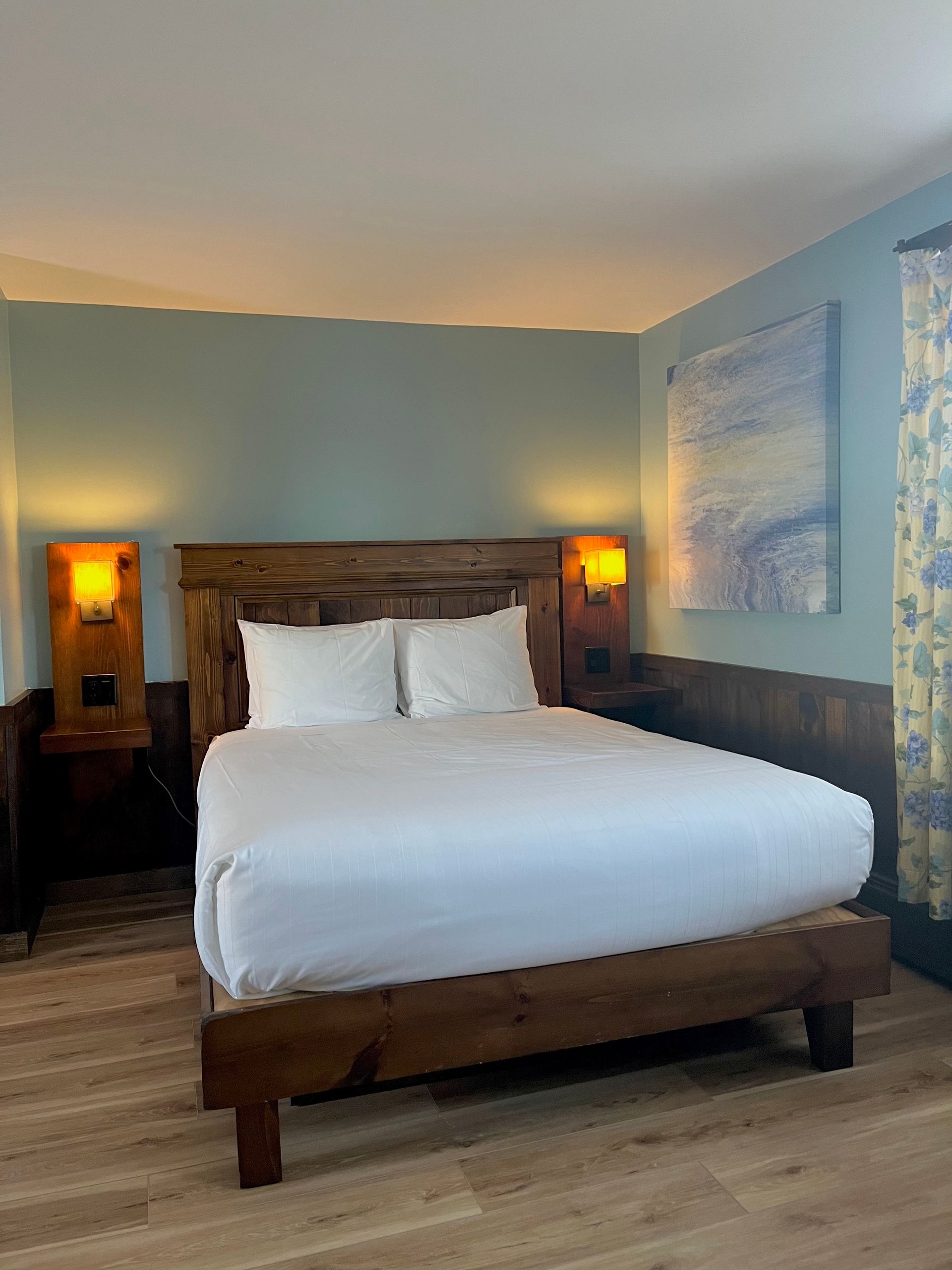 A hotel room with a king size bed and two nightstands.