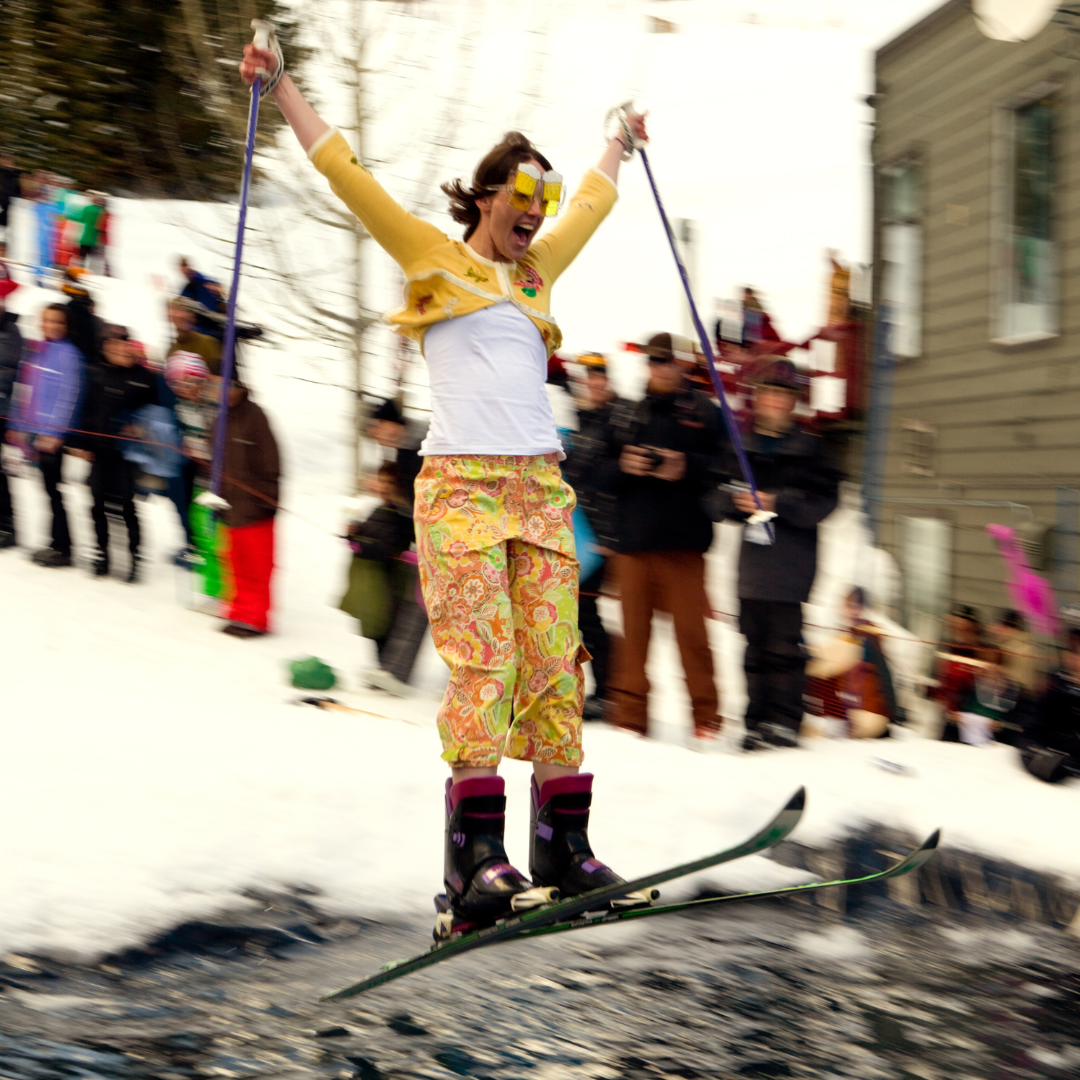 Woman in funny costume doing a springtime pond skim on skis