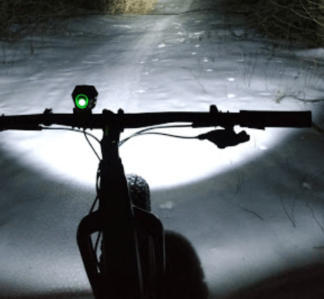 A snow-covered path is lit by a MTB light at The Wildflower
