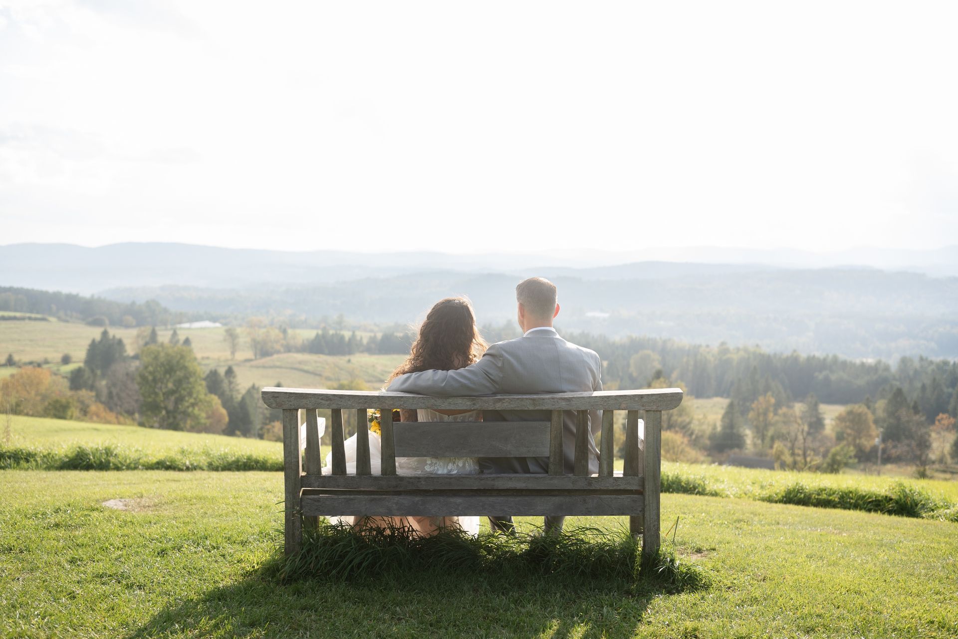 A bride and groom sit on Heaven's Bench at The Wildflower after their Vermont elopement