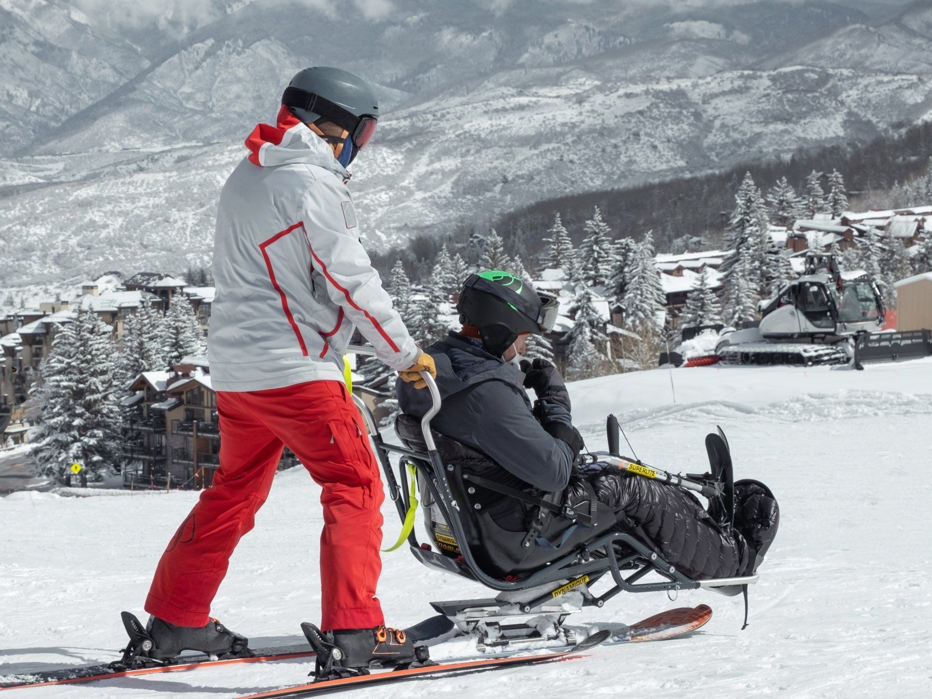 Two people adaptive skiing on a sit ski