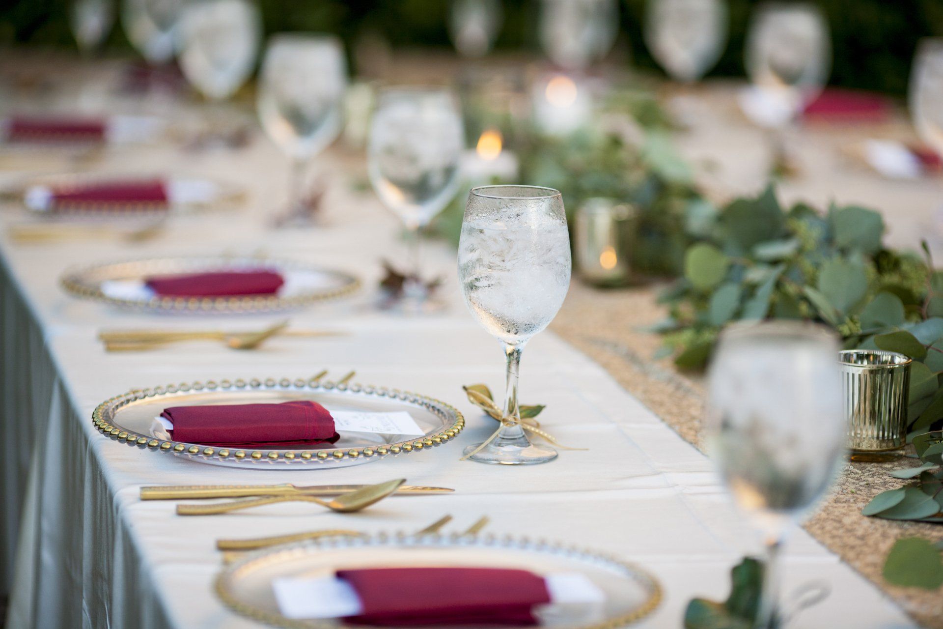 Elegant winter wedding place settings with gold and burgundy accents