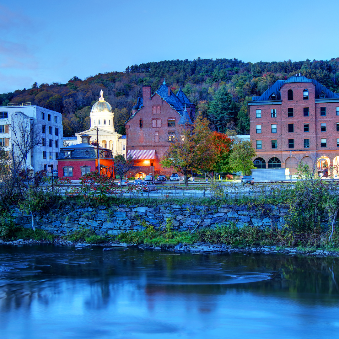 Montpelier, Vermont at sunset with the capital building illuminated from across the river.
