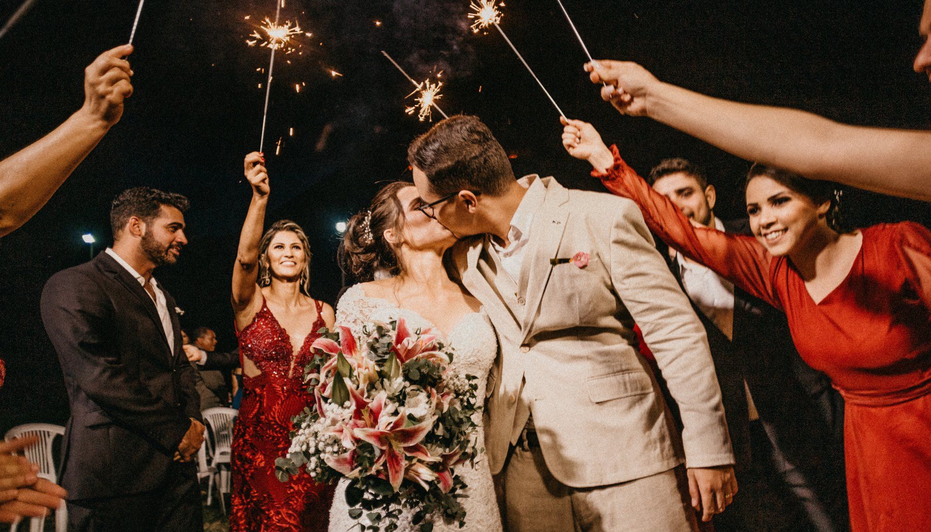 A bride and groom exiting their wedding beneath sparklers