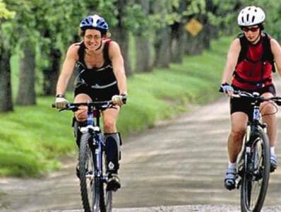 Two women pedal along the main road at The Wildflower