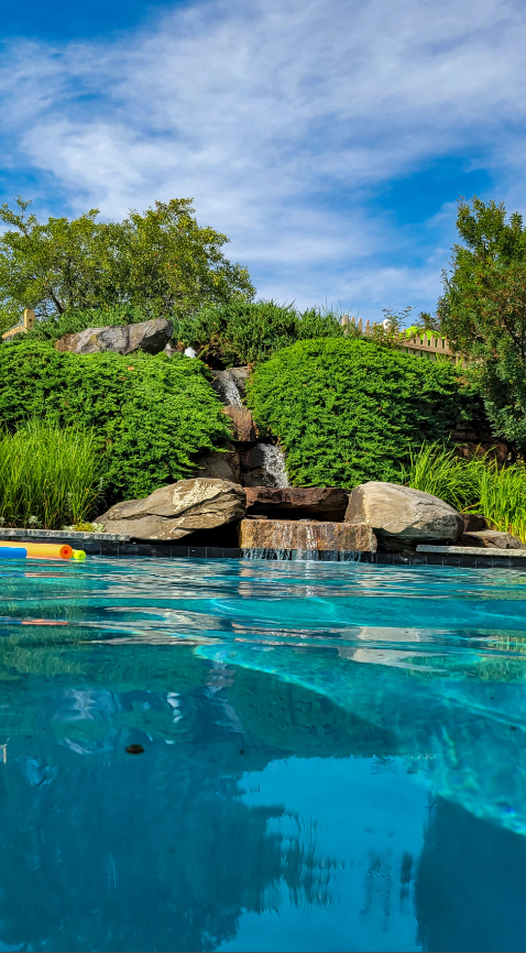 A beautiful heated swimming pool with a waterfall at The Wildflower Inn