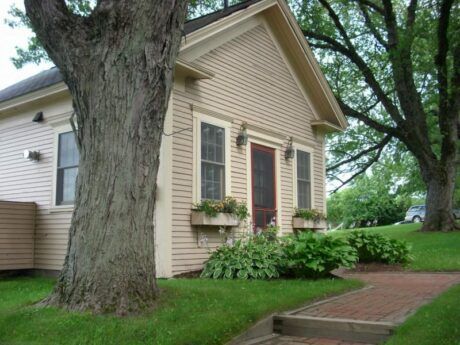 A small house with a tree in front of it