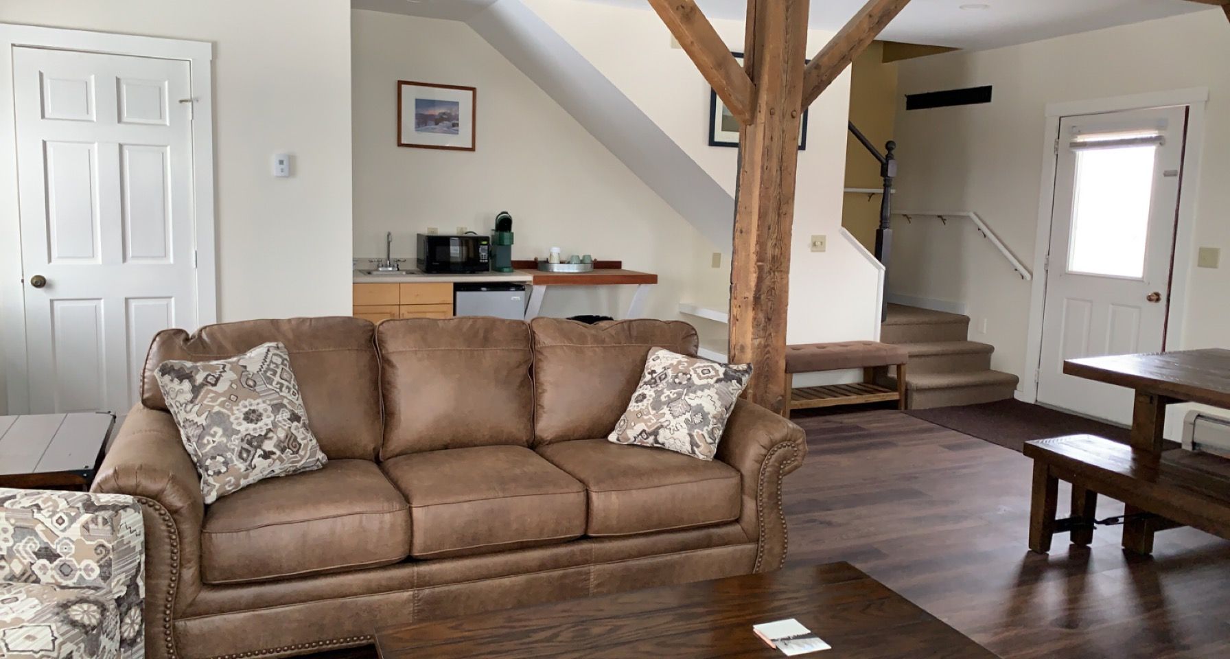 A living room with a brown couch and a wooden table.