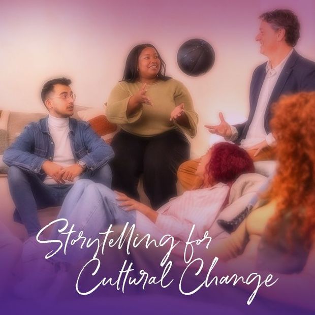 Woman in a purple blazer speaks from behind a podium, holding a folder. Dark background.