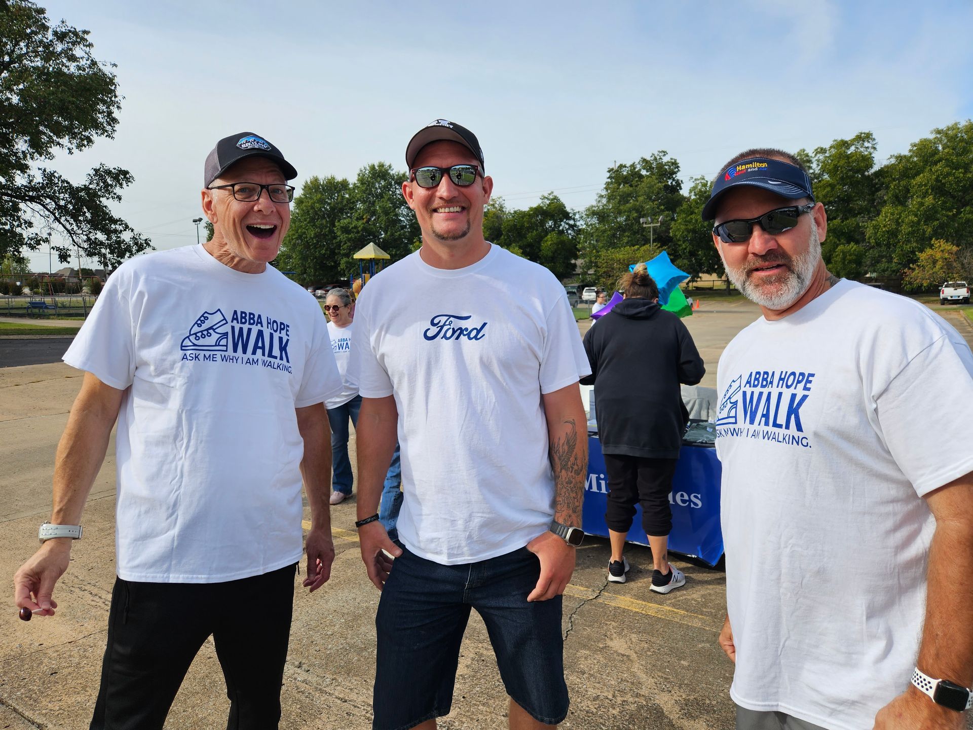 Three men wearing ford shirts are posing for a picture
