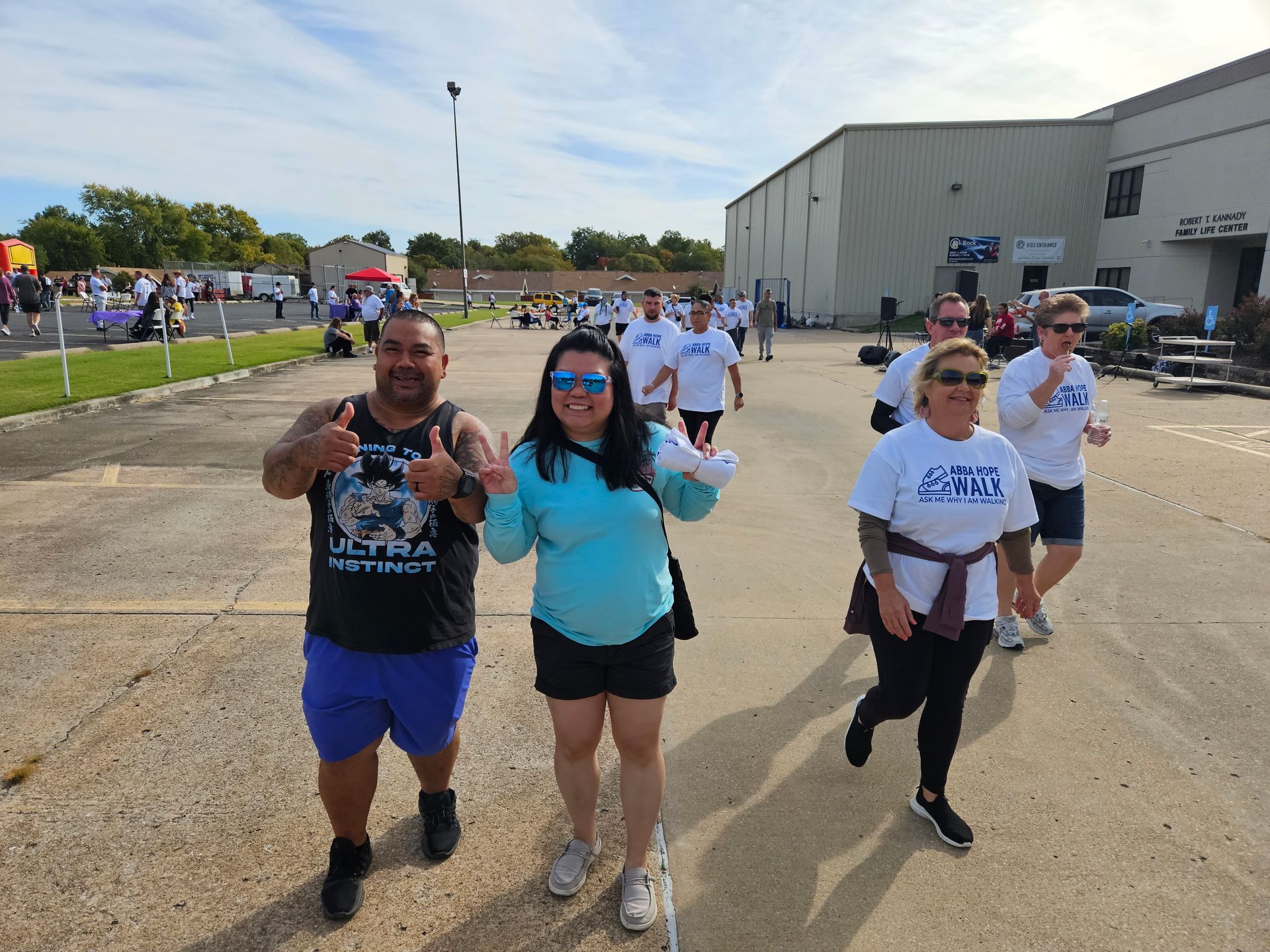 A group of people are walking down a street in front of a building.
