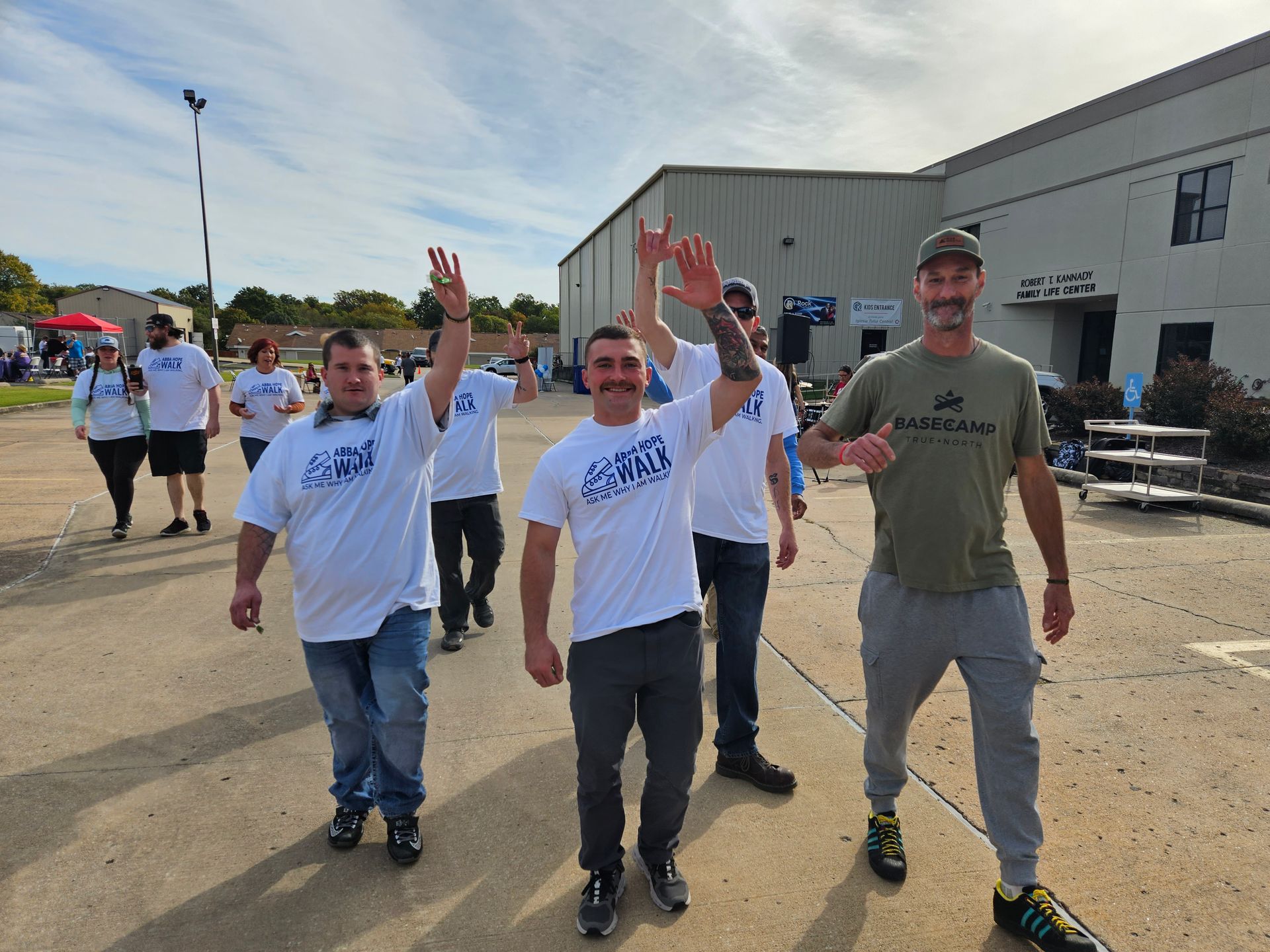 A group of men are walking down a street with their arms in the air.