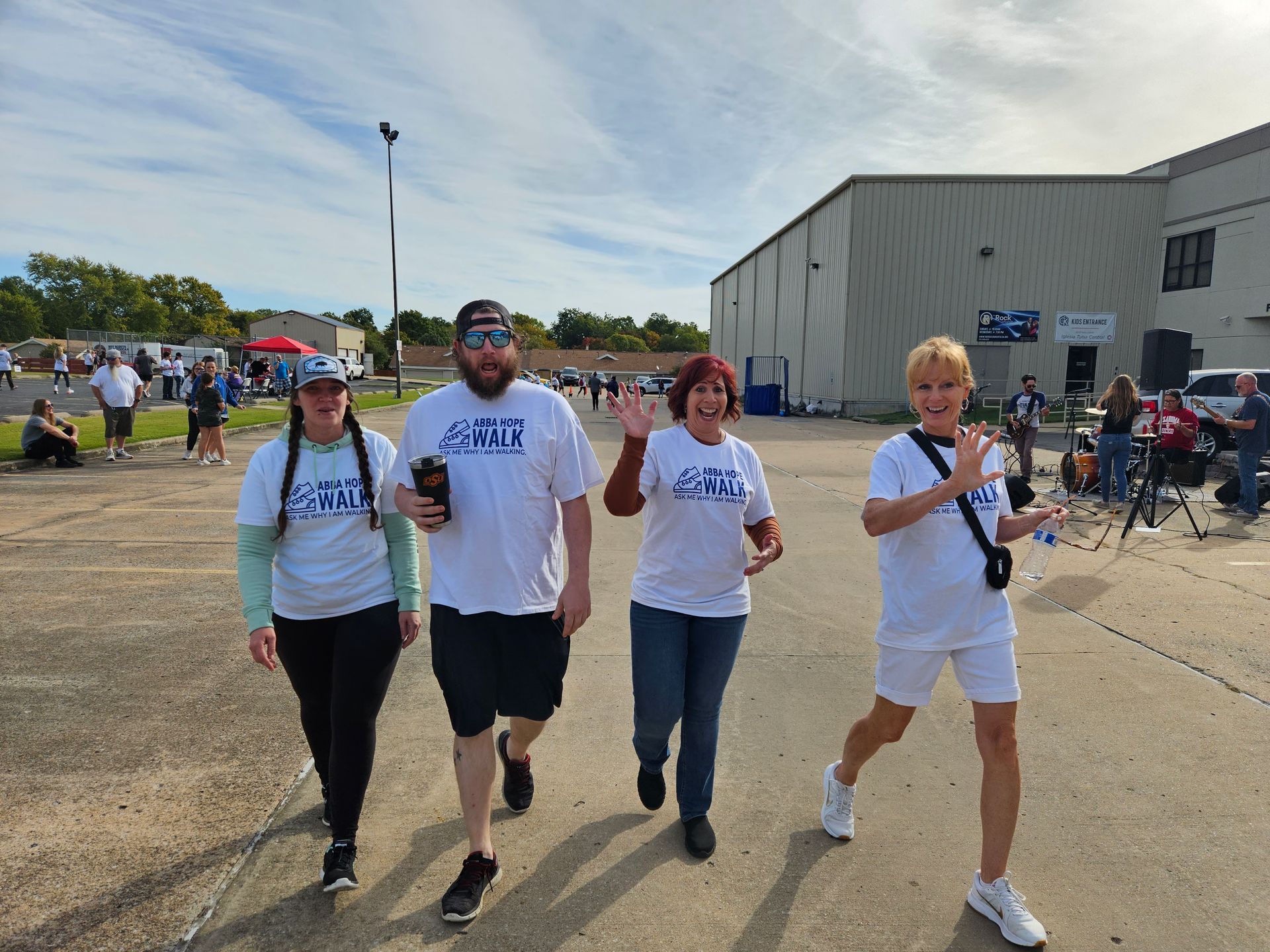 A group of people are walking down a street in front of a building.