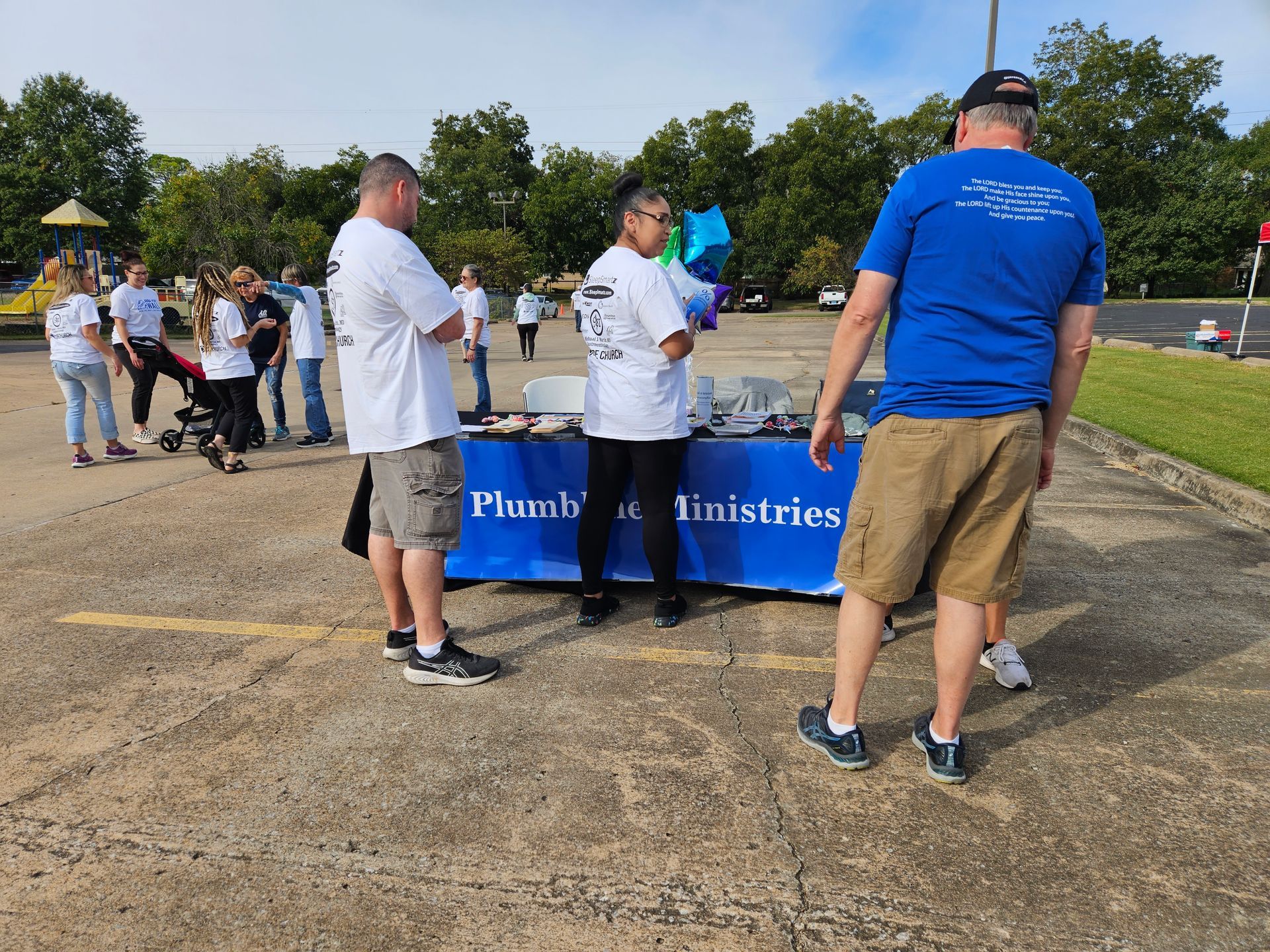 A group of people standing around a table that says plumbing ministries
