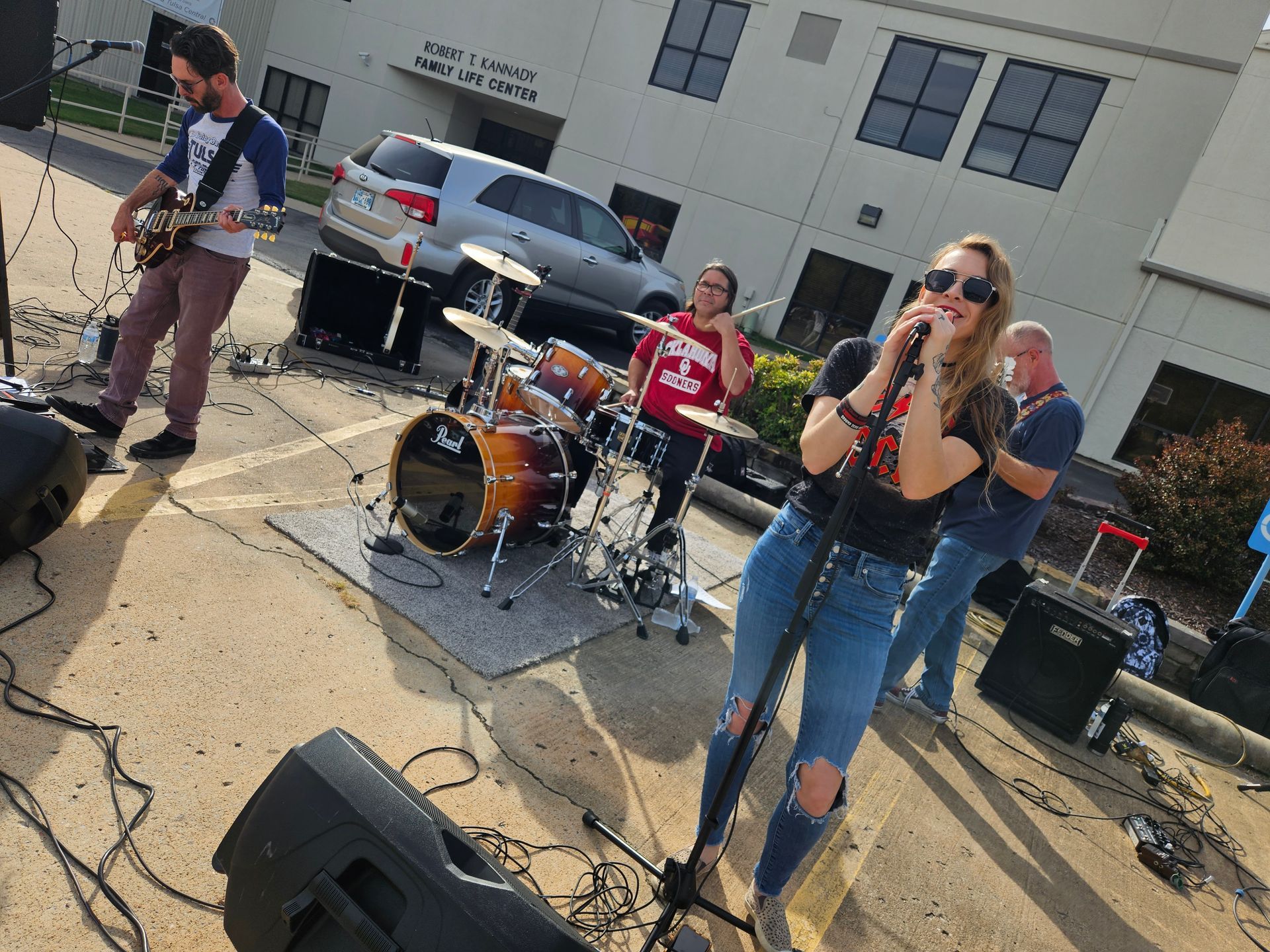 A group of people are playing instruments on a stage in front of a building.
