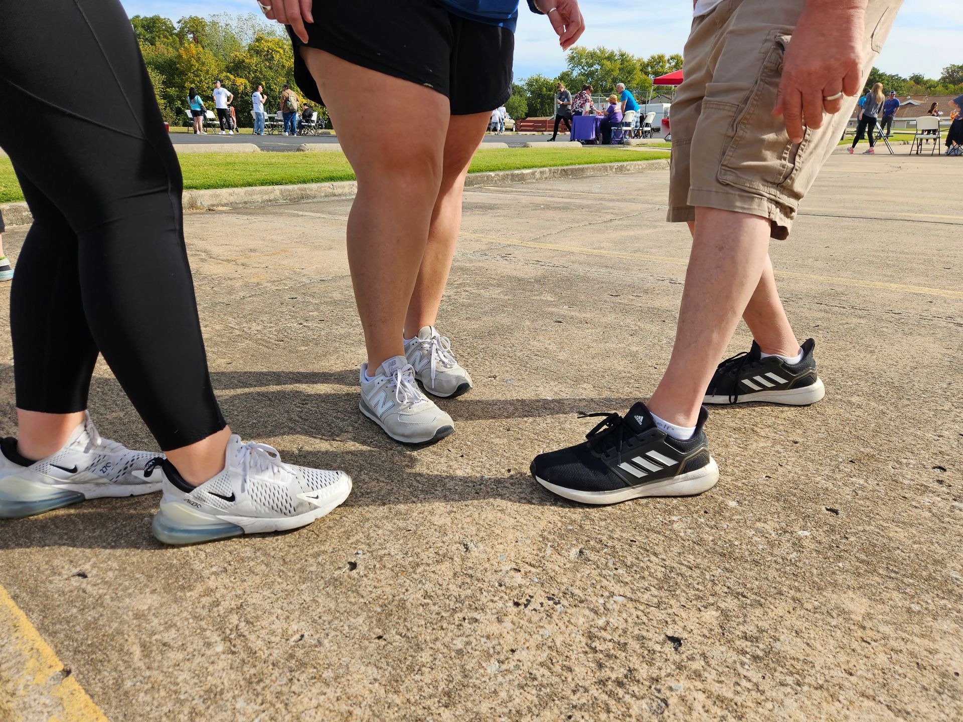 A group of people standing next to each other on a sidewalk.