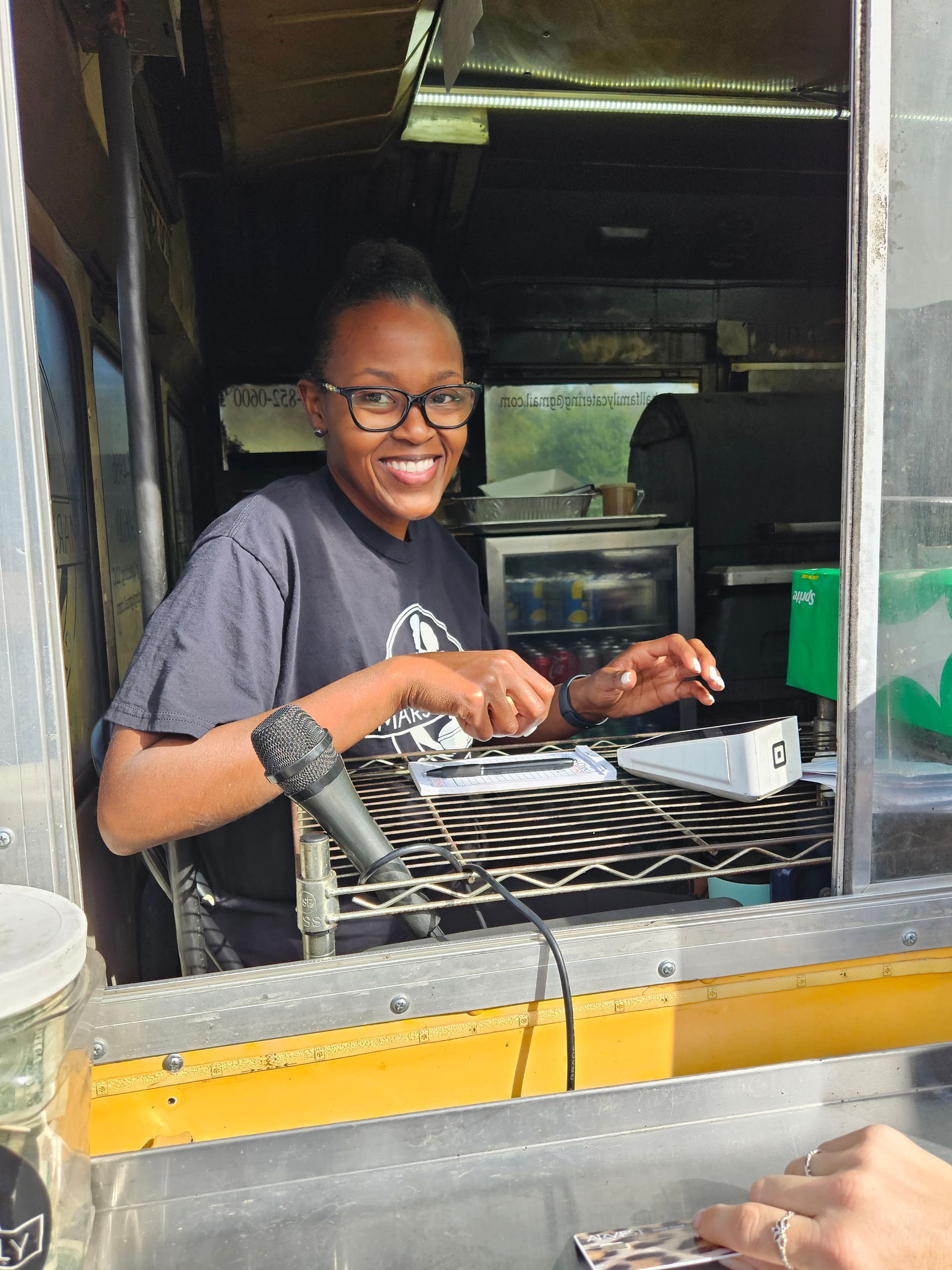 A woman is sitting in a food truck with a microphone in her hand.