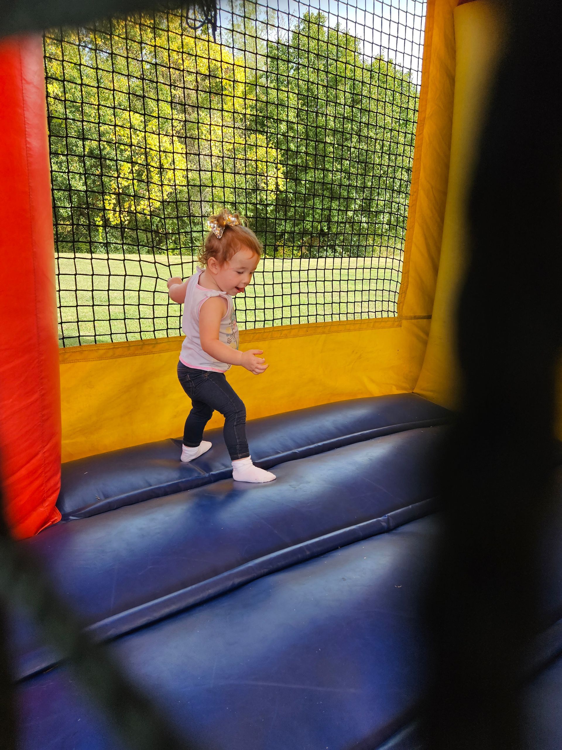 A little girl is playing in a bouncy house.
