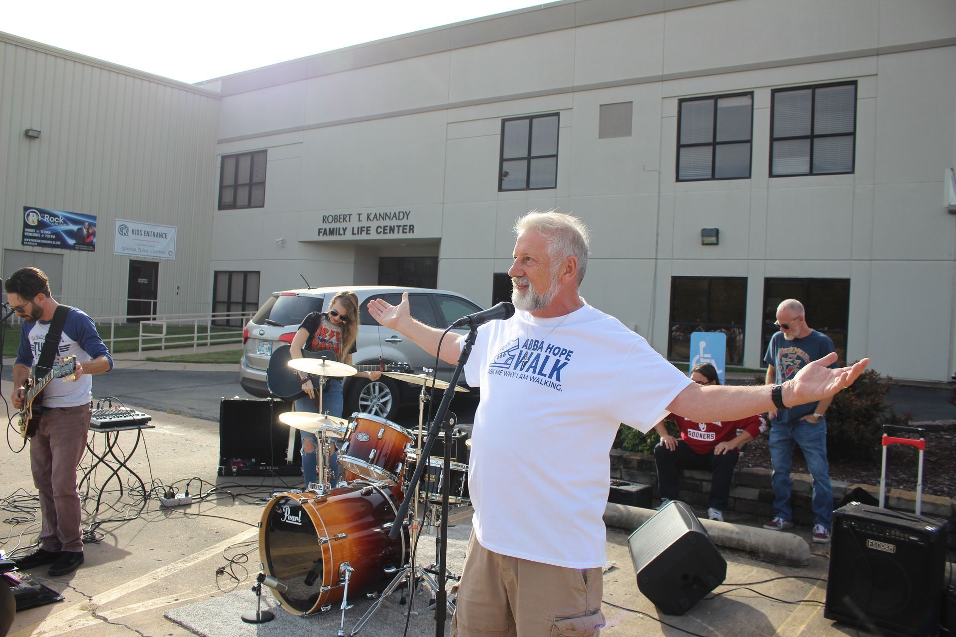 A man standing in front of a microphone with his arms outstretched