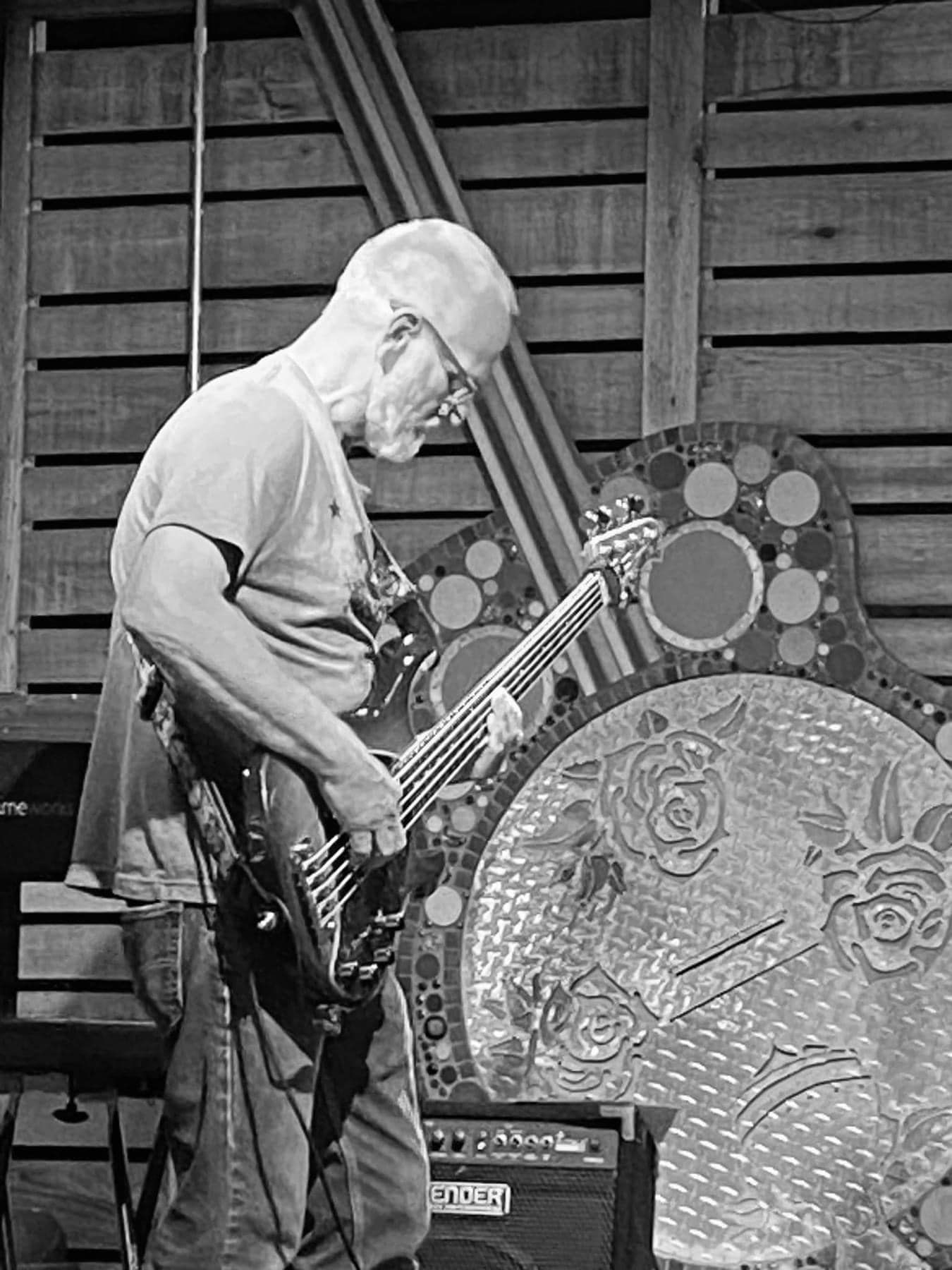 A man is playing a guitar in a black and white photo.