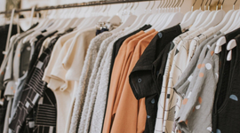 Manna House row of clothes hanging on a rack in a store.