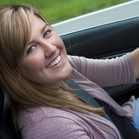 women smiling inside her car