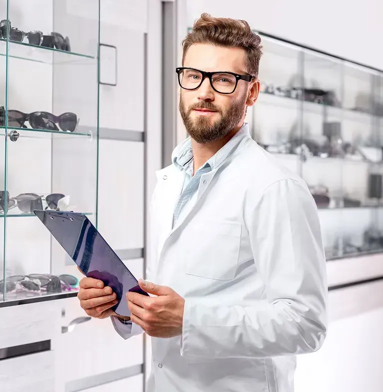 A man in a lab coat and glasses is holding a clipboard.