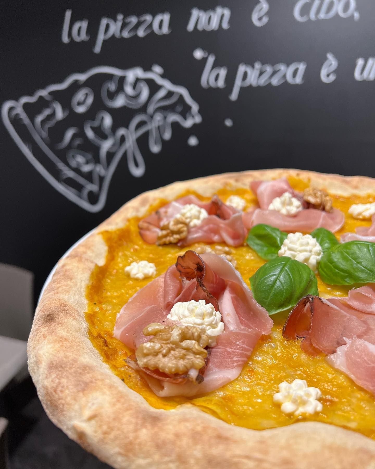 Una pizza è seduta davanti a una lavagna che dice la pizza non è cibo
