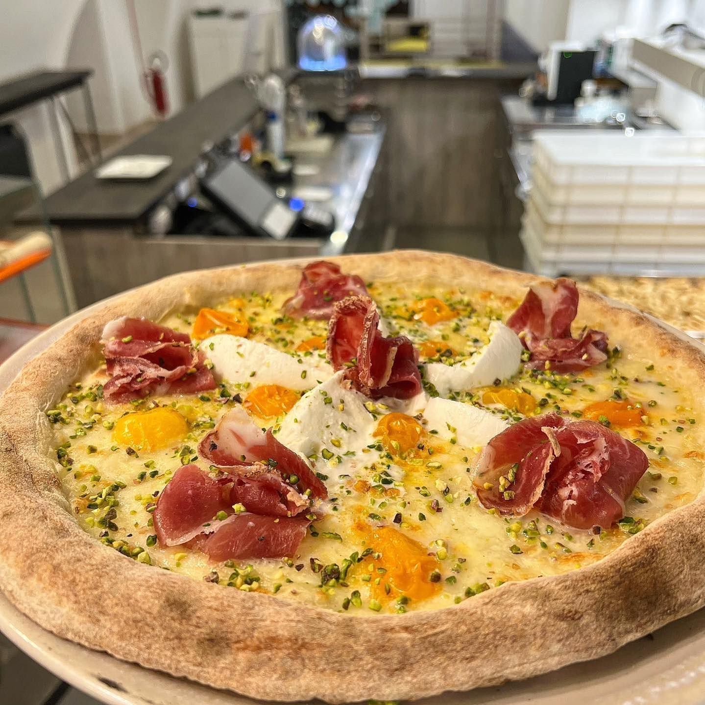 Una pizza con molti condimenti è su un piatto.