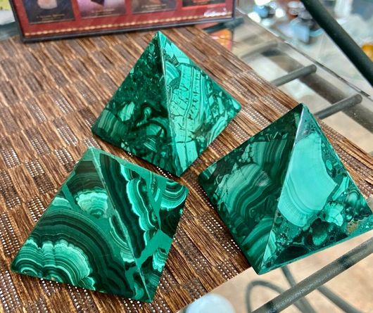 Three green malachite pyramids are sitting on a table.