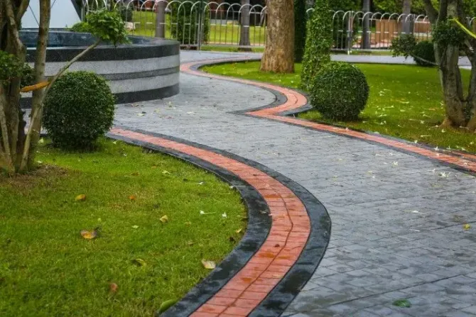 Elegant curved concrete walkway with decorative brick border.