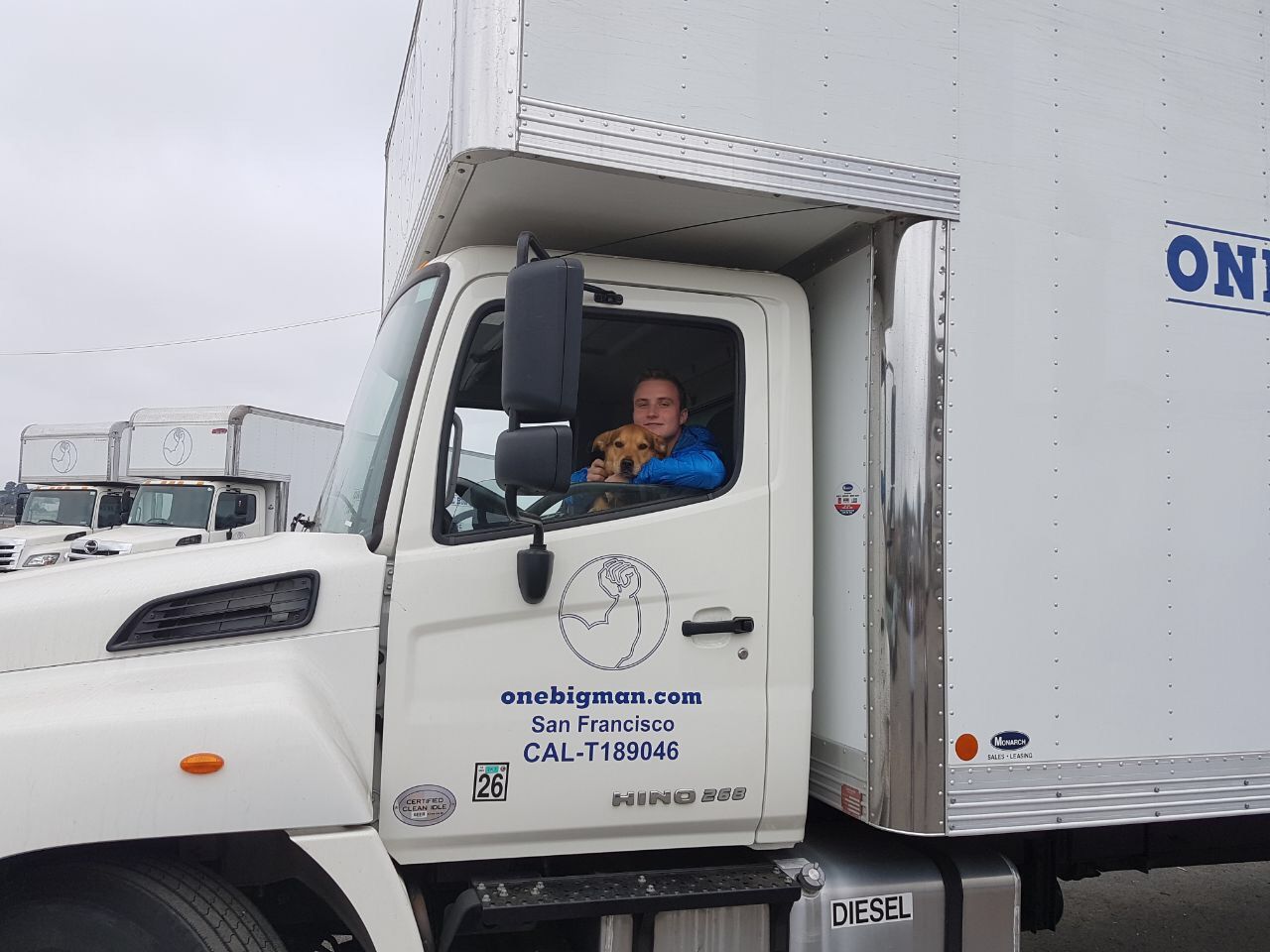 A man is sitting in the driver 's seat of a white truck