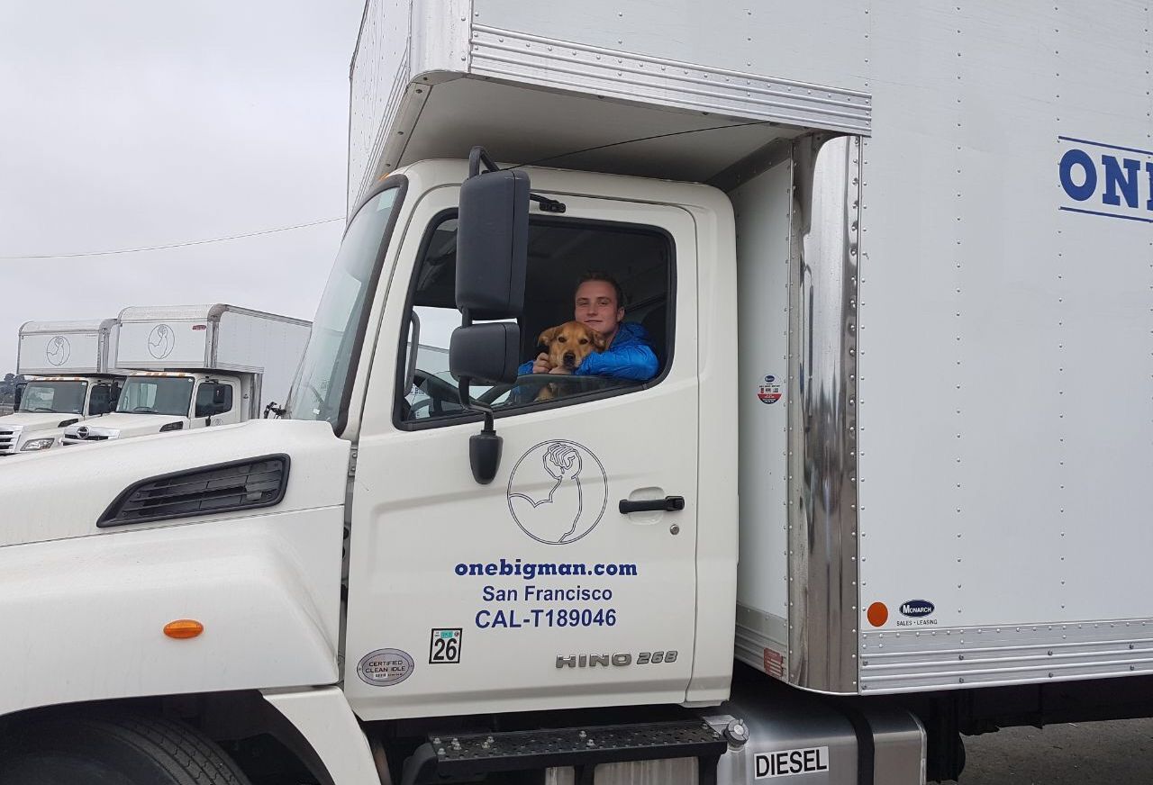 A man is sitting in the driver 's seat of a white truck