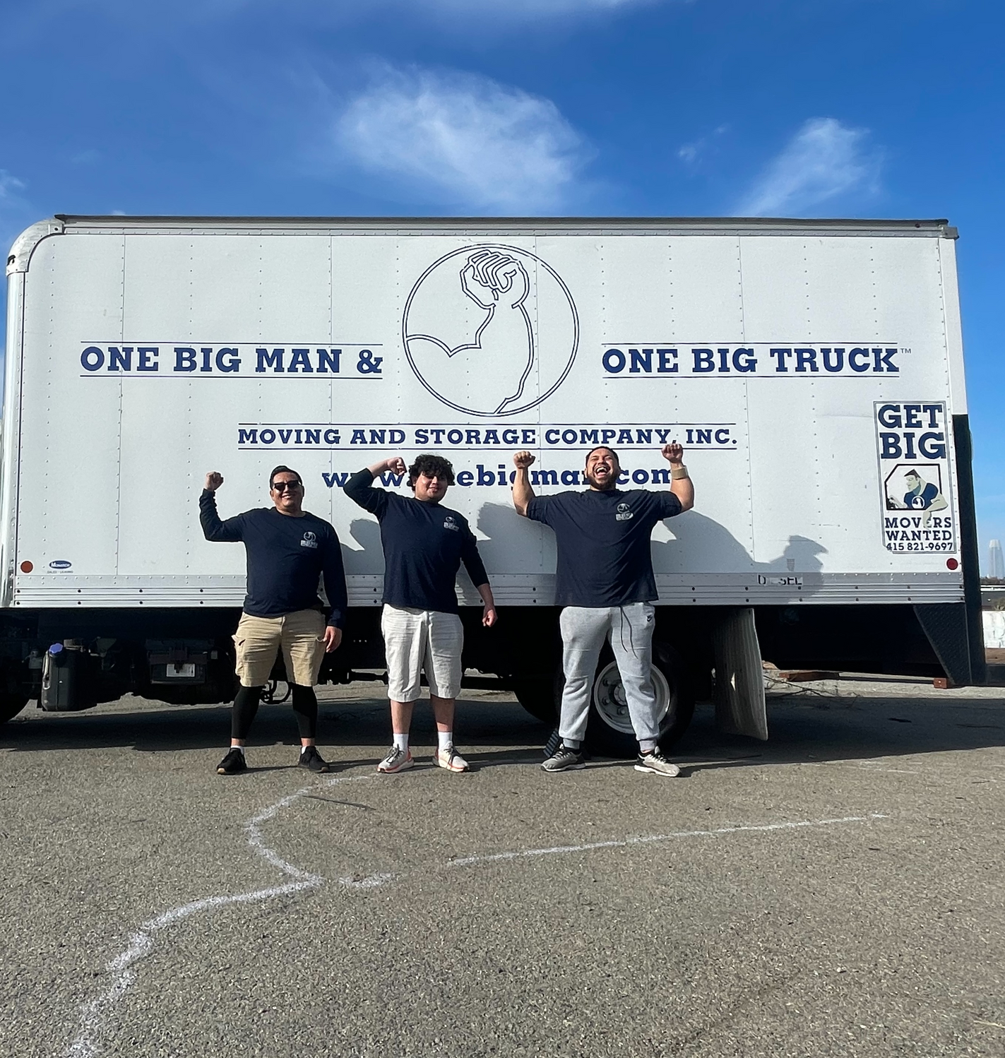 Three people stand in front of a white moving truck under a blue sky, flexing. The truck says 