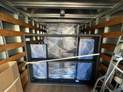 A moving truck filled with furniture and boxes.