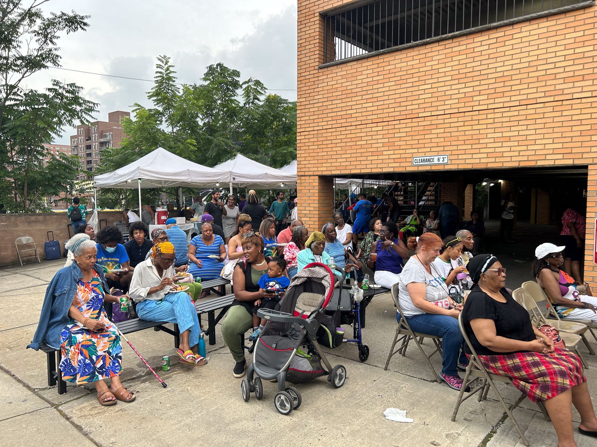 A group of people are sitting in chairs outside of a building.