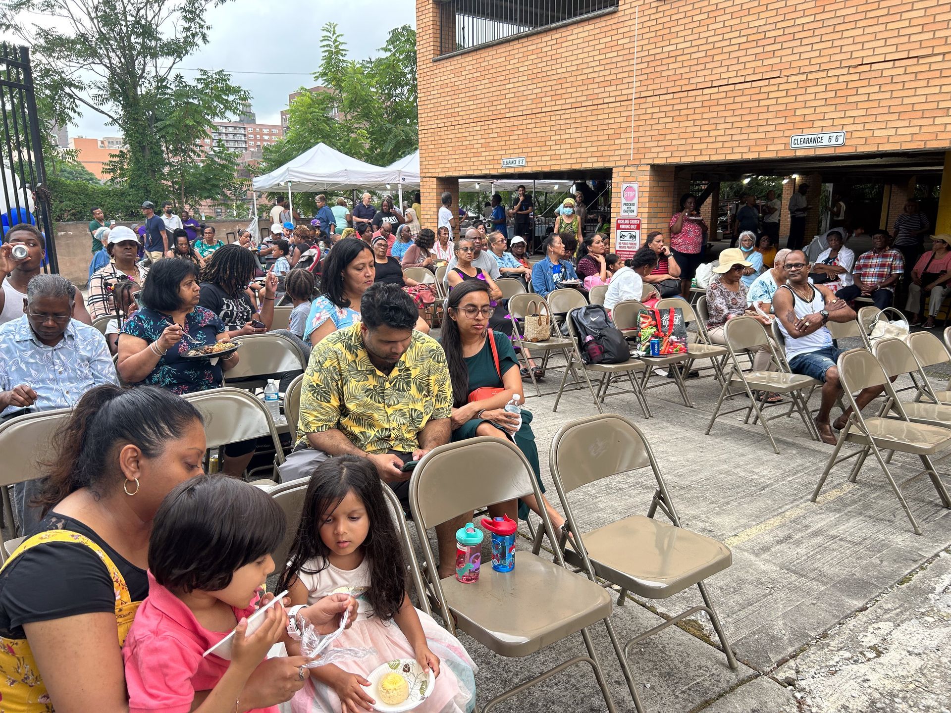 A group of people are sitting in folding chairs eating ice cream.