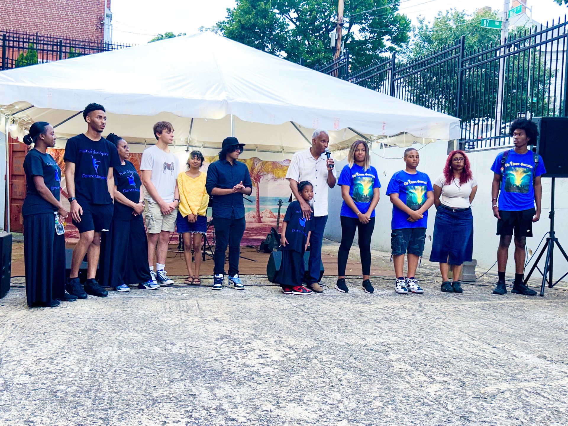 A group of people standing in front of a white tent.