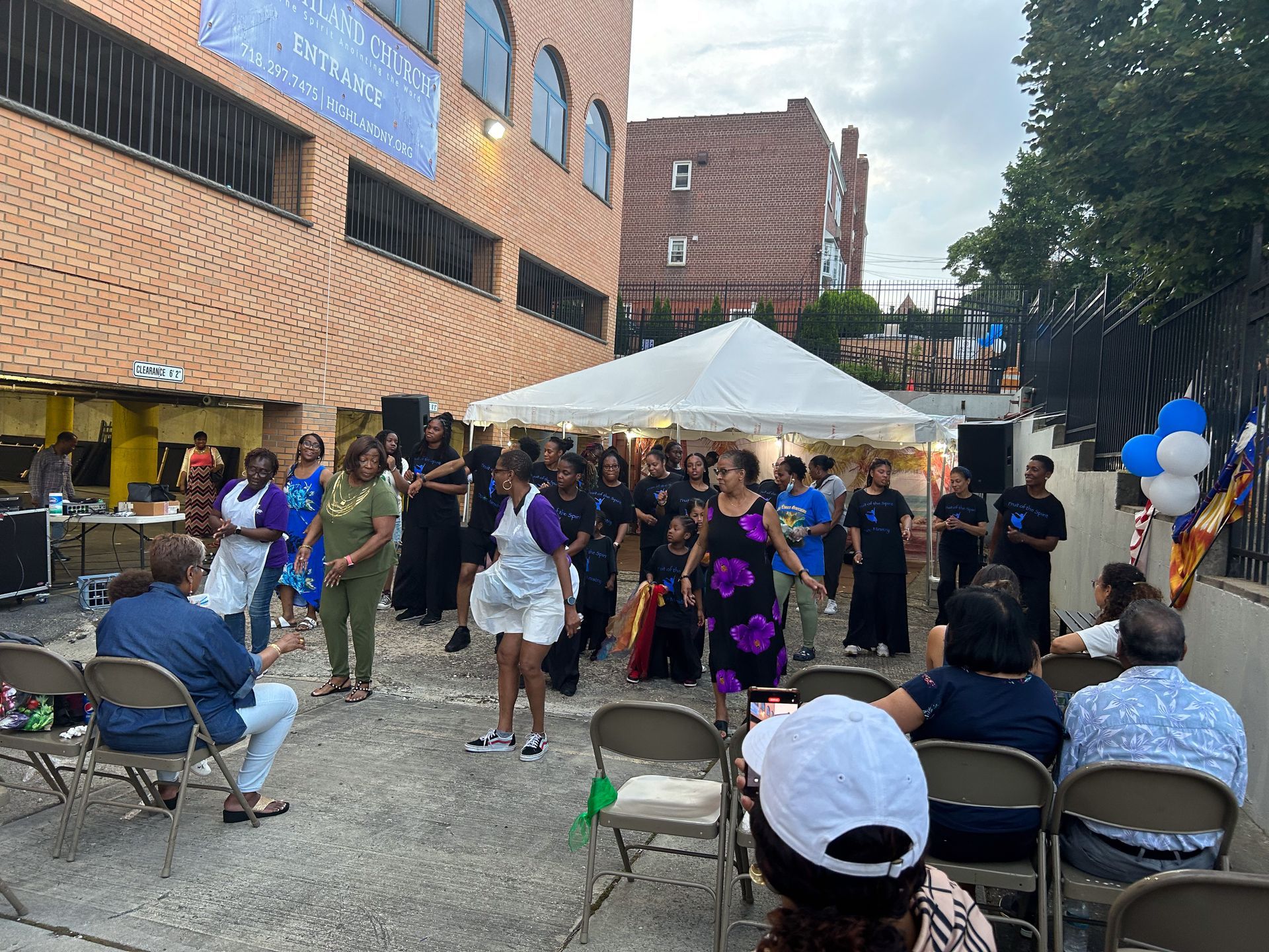 A group of people are dancing in front of a building.