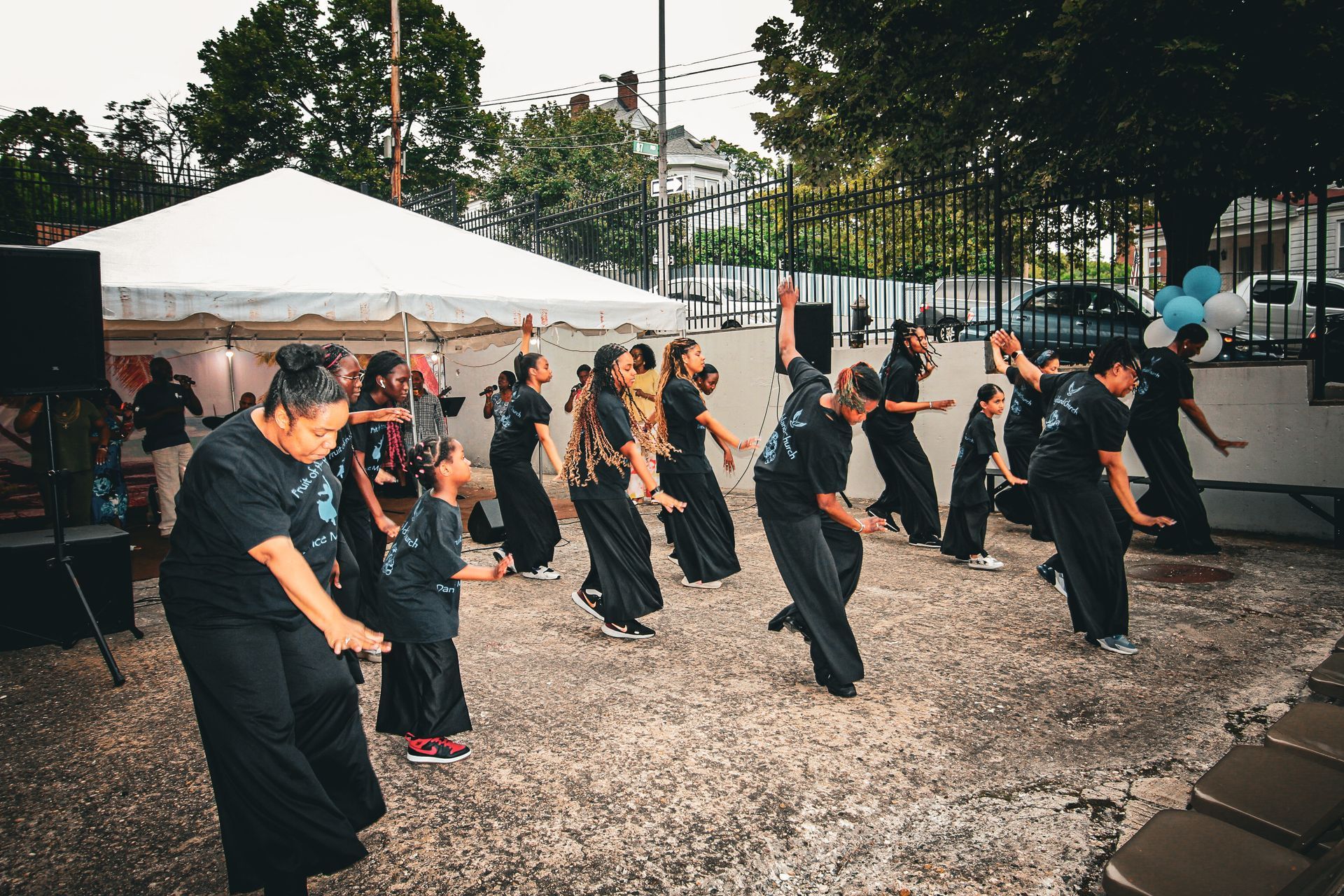 A group of people are dancing in a park.