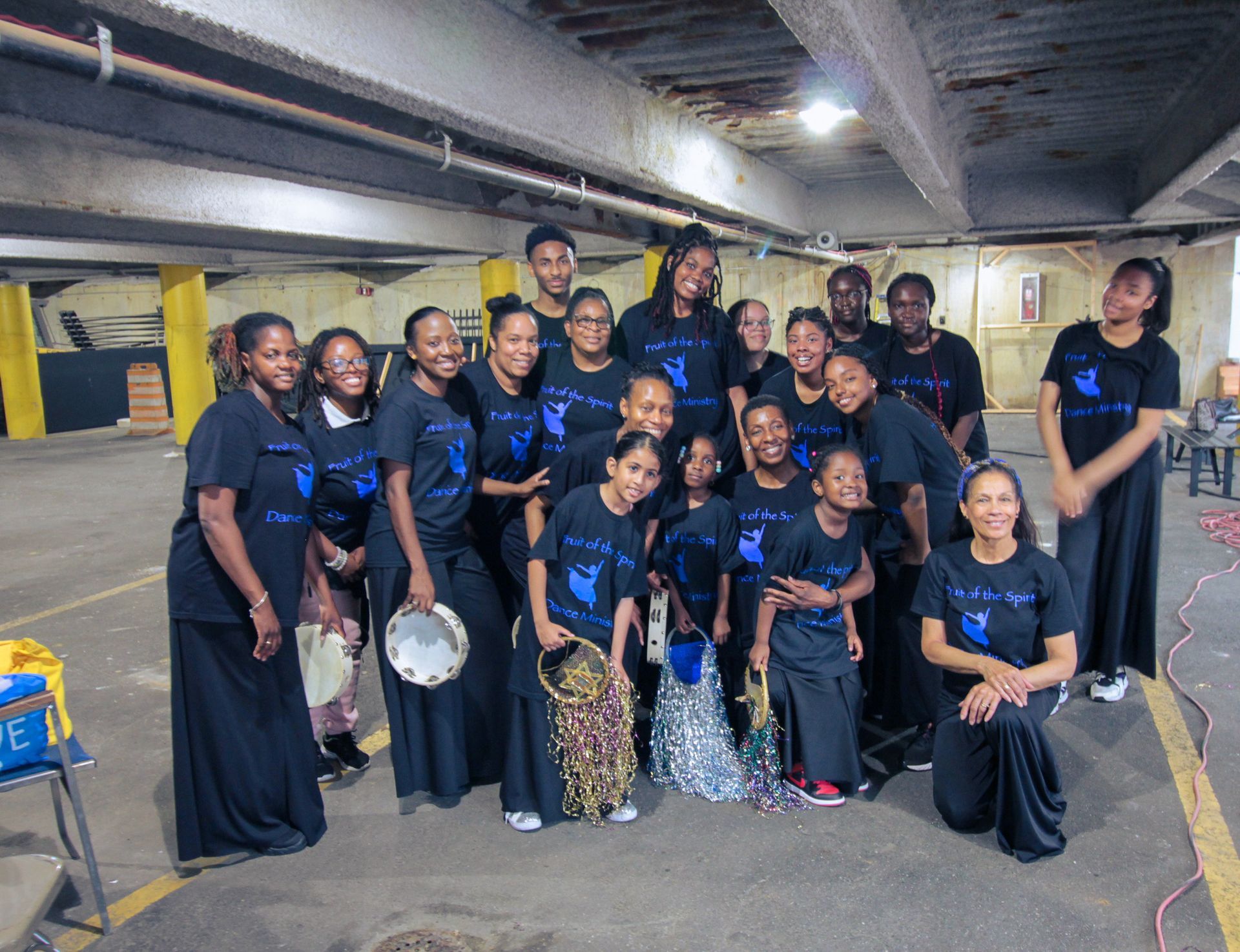A group of people are posing for a picture in a parking garage.
