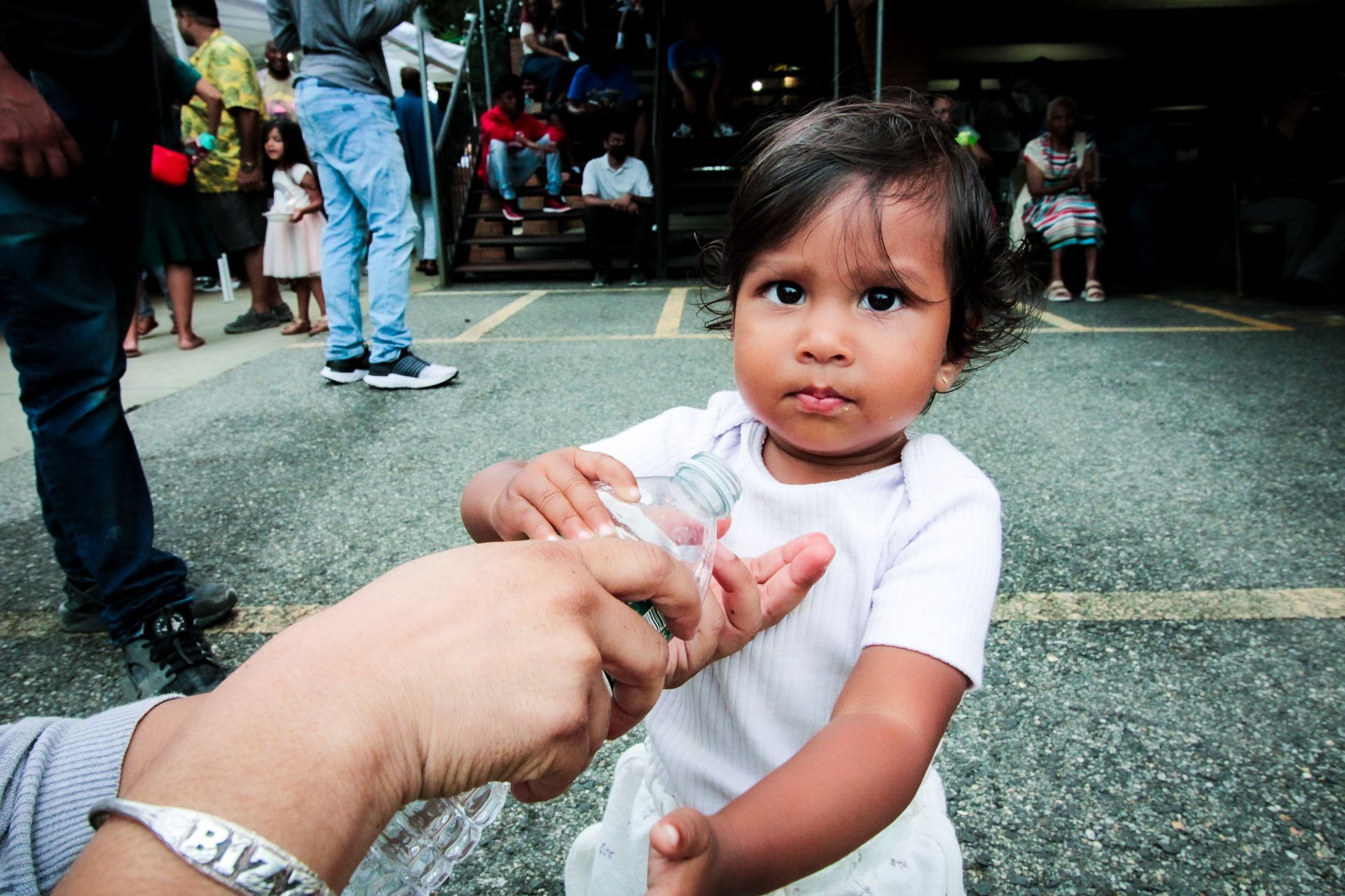 A person is giving a baby a bottle of water