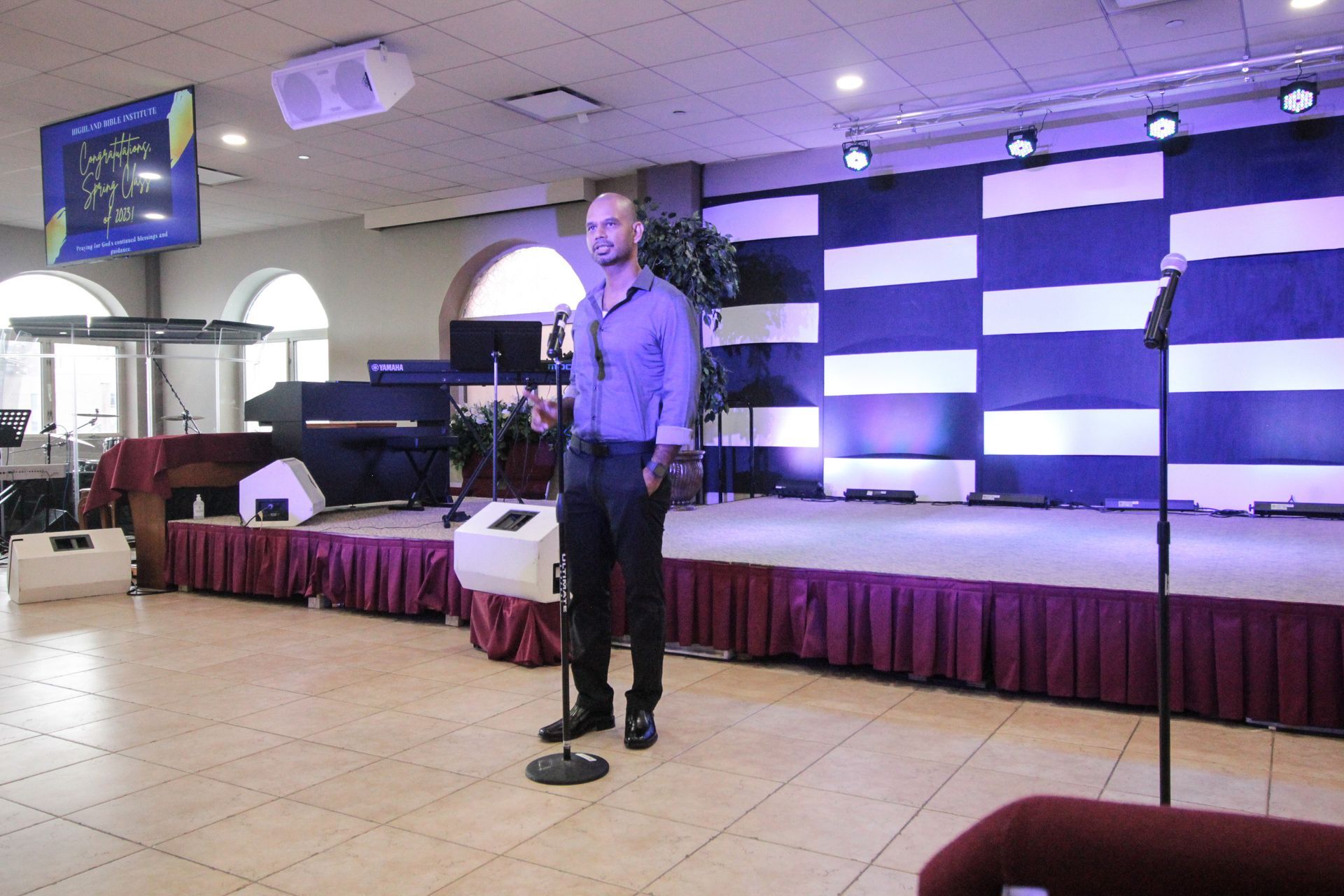 A man is standing in front of a microphone on a stage