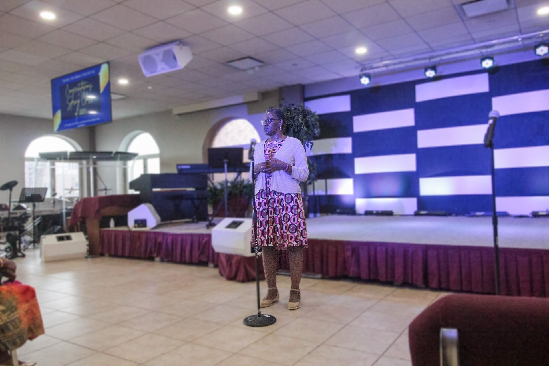 A woman is standing in front of a microphone on a stage.