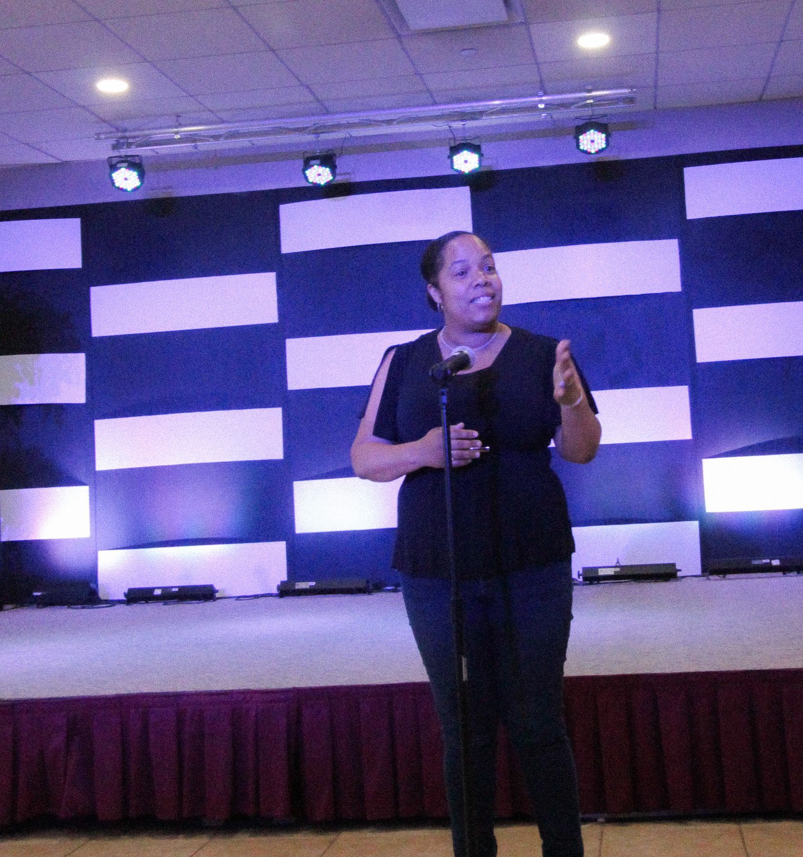 A woman singing into a microphone on a stage