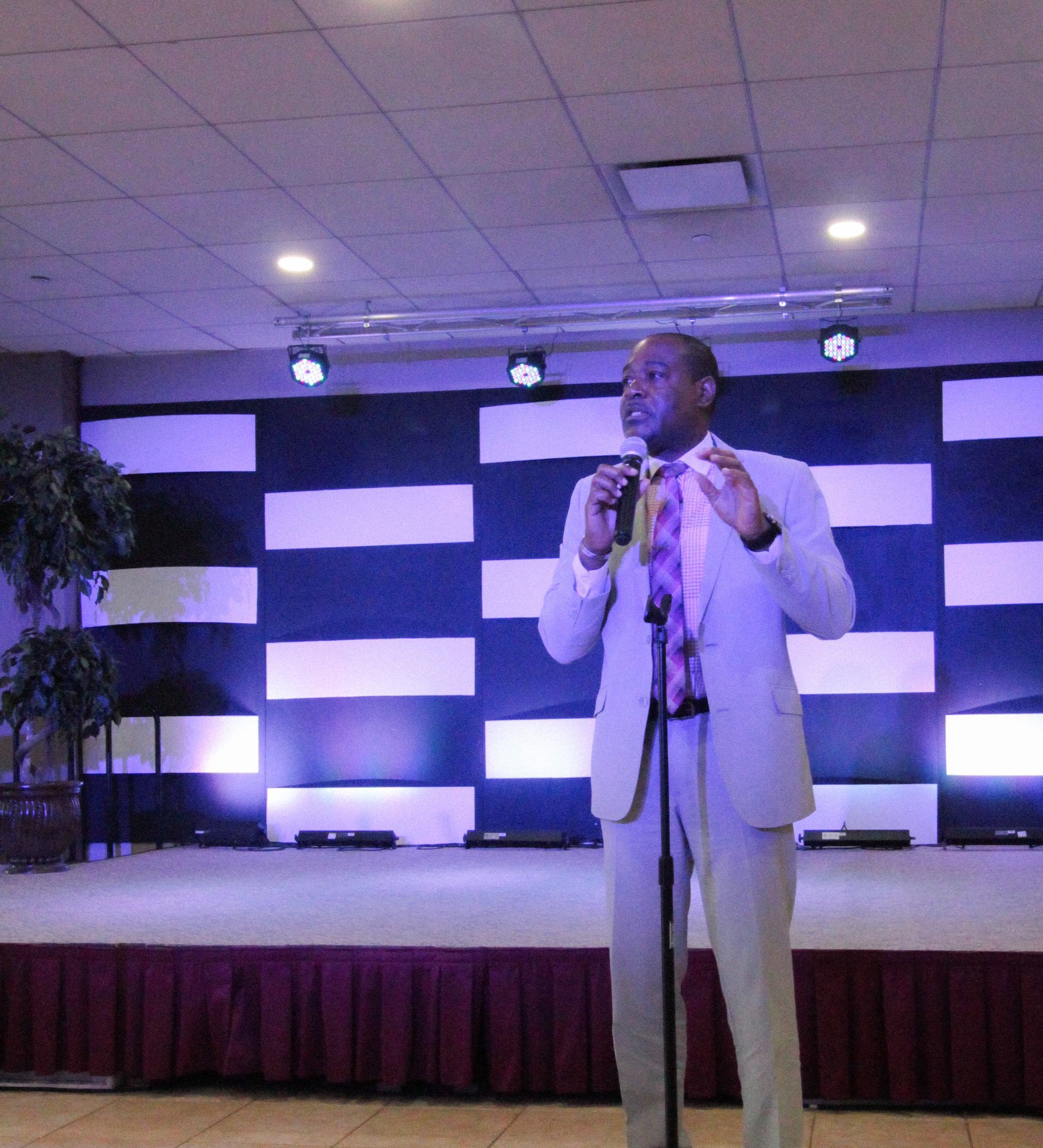 A man in a suit is speaking into a microphone