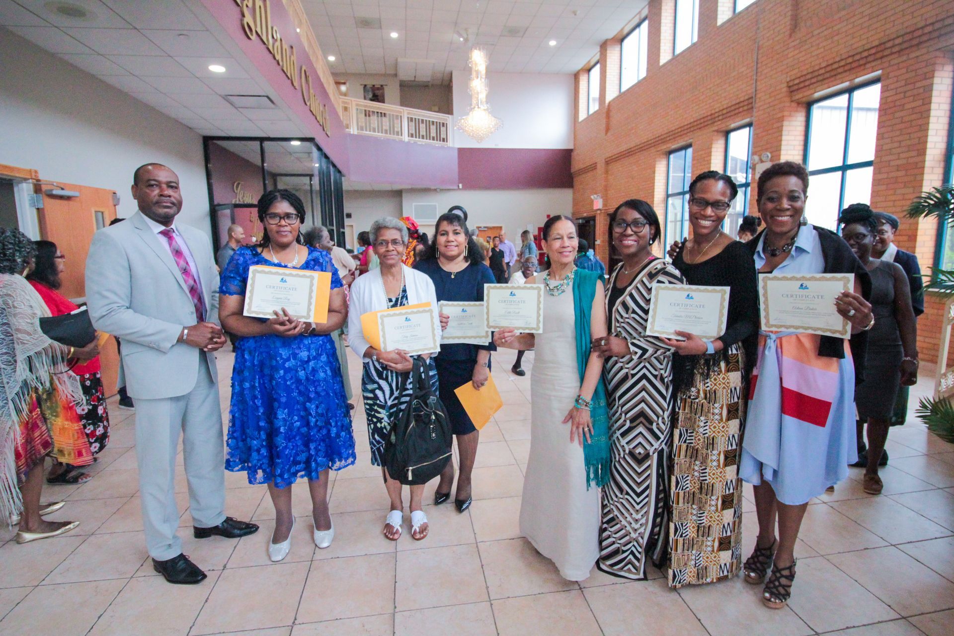 A group of people standing next to each other holding certificates.