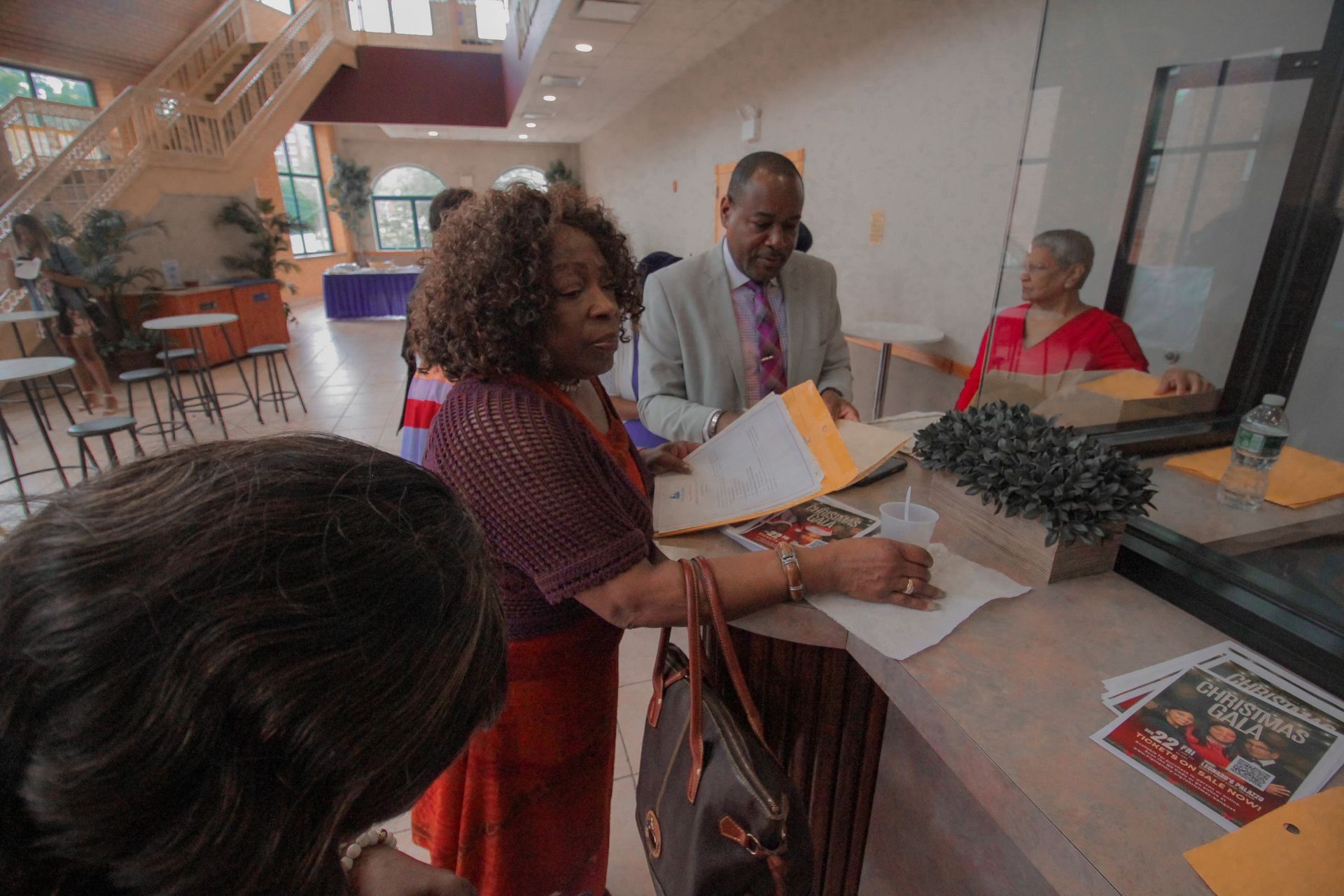 A group of people are standing around a counter in a room.