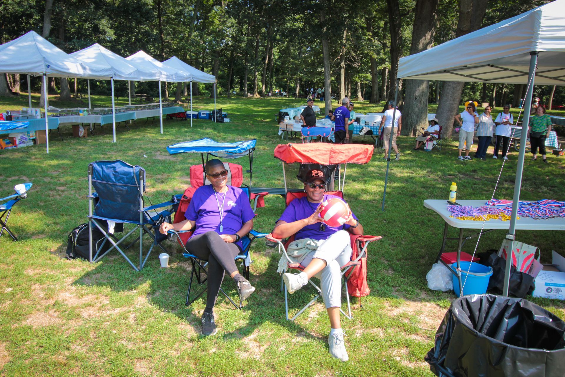Two people are sitting in chairs in a park.