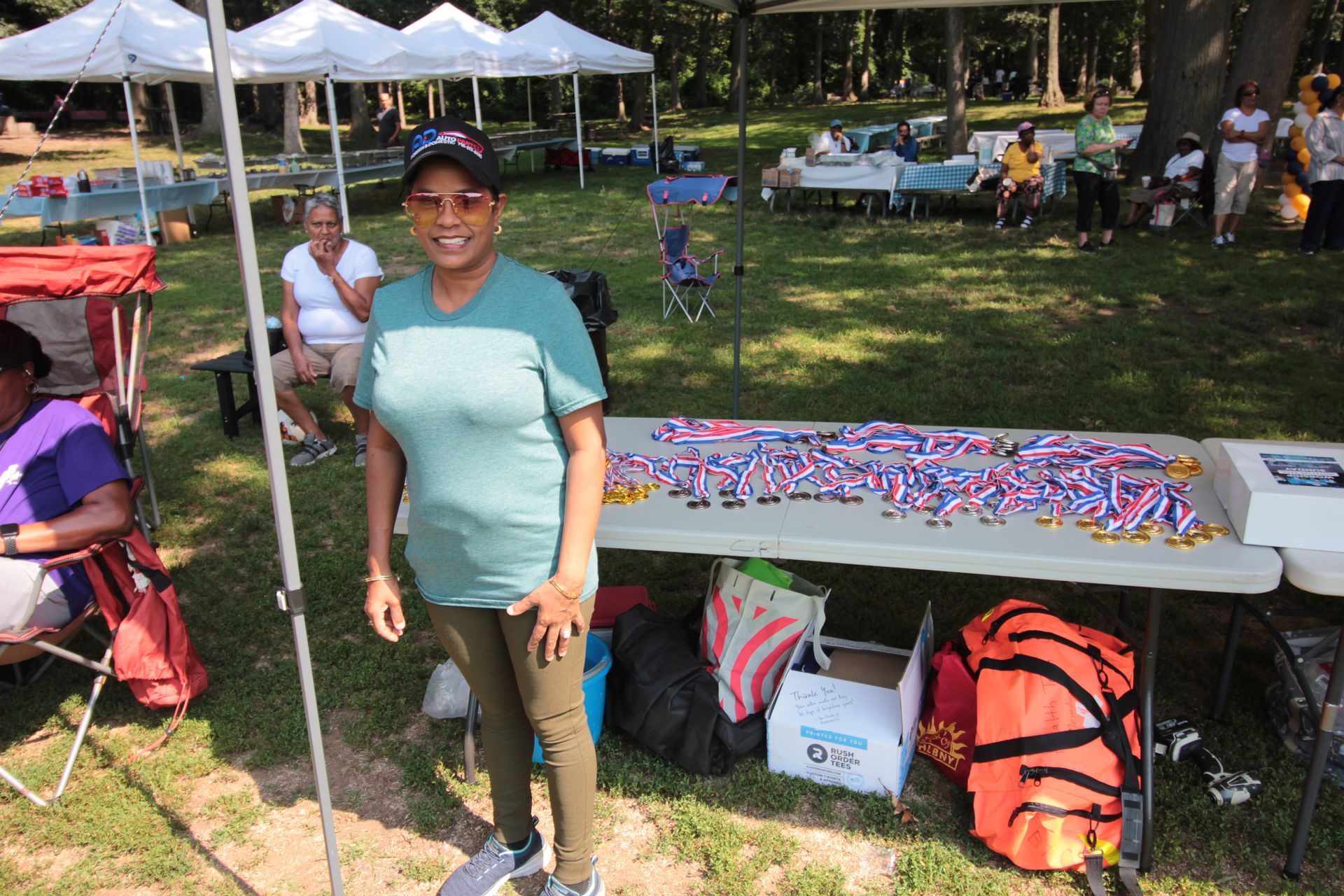 A woman is standing in front of a table with medals on it.
